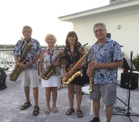 A group of people holding saxophones.